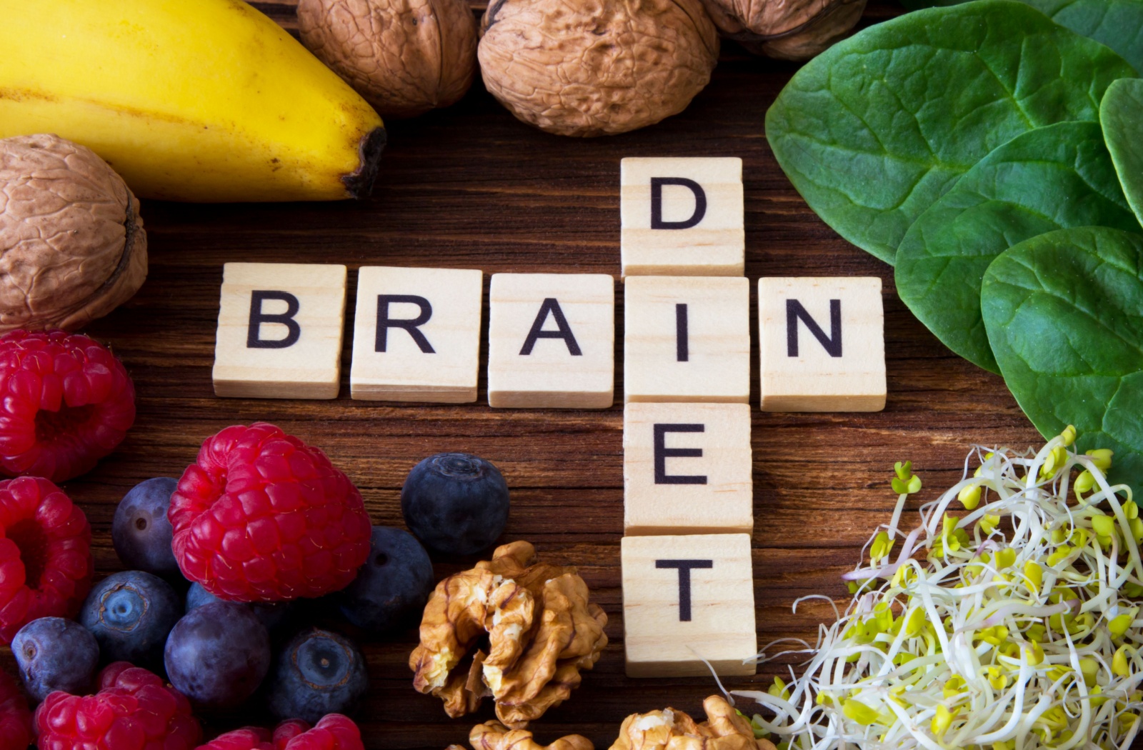 The words “brain” and “diet” on blocks intersect at the “i,” surrounded by foods that help support brain health